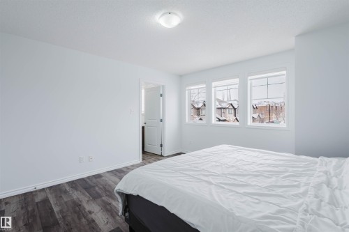 Bedroom with dark wood-type flooring and a textured ceiling - Edmonton, AB - Indoor Photo Showing Bedroom