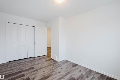 Unfurnished bedroom featuring wood finished floors, a closet, and a textured ceiling - Edmonton, AB - Indoor Photo Showing Other Room