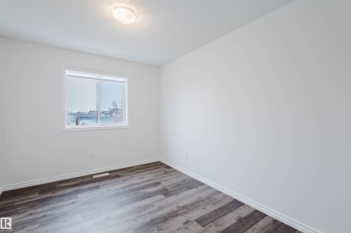 Unfurnished room featuring wood finished floors and a textured ceiling - Edmonton, AB - Indoor Photo Showing Other Room