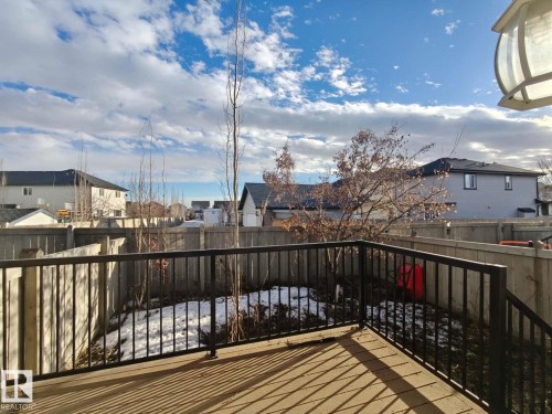 The property features a wood deck with black metal railings, overlooking a fenced yard - Edmonton, AB - Outdoor