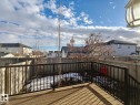 The property features a wood deck with black metal railings, overlooking a fenced yard - Edmonton, AB  - Outdoor 