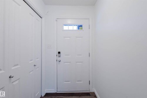 Doorway to outside with baseboards and wood finished floors - Edmonton, AB - Indoor Photo Showing Other Room
