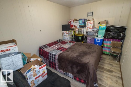 This room features paneled walls and wood-look flooring - 5016 47 St, Myrnam, AB - Indoor