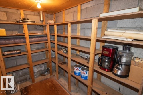 The property features a dedicated storage room with extensive wooden shelving - 5016 47 St, Myrnam, AB - Indoor