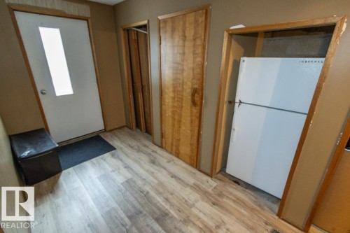 Entryway featuring light-toned flooring, a white door with a window, and a built-in refrigerator - 5016 47 St, Myrnam, AB - Indoor Photo Showing Other Room