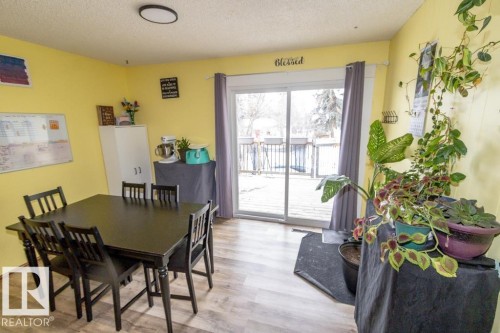 This room features light-colored flooring and a sliding glass door providing access to an outdoor deck - 5016 47 St, Myrnam, AB - Indoor Photo Showing Dining Room