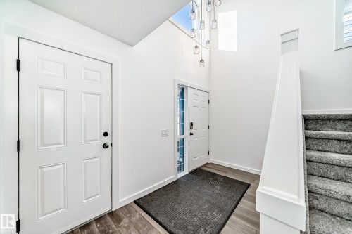 Foyer entrance with wood finished floors and a high ceiling - 4008 37 Avenue, Edmonton, AB - Indoor Photo Showing Other Room