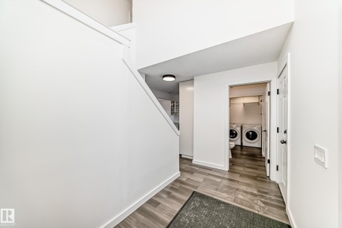 Hall featuring light wood-style floors and washing machine and dryer - 4008 37 Avenue, Edmonton, AB - Indoor Photo Showing Other Room
