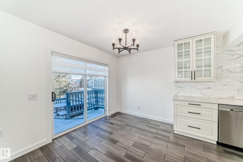 Unfurnished dining area with wood tiled floors and a chandelier - 4008 37 Avenue, Edmonton, AB - Indoor