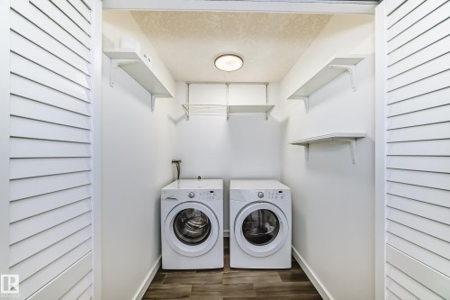 Laundry area featuring a textured ceiling, dark wood-style flooring, and washer and clothes dryer - 4008 37 Avenue, Edmonton, AB - Indoor Photo Showing Laundry Room