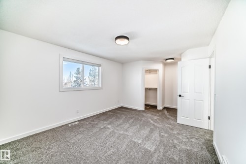 Unfurnished bedroom with a walk in closet and carpet - 4008 37 Avenue, Edmonton, AB - Indoor Photo Showing Other Room