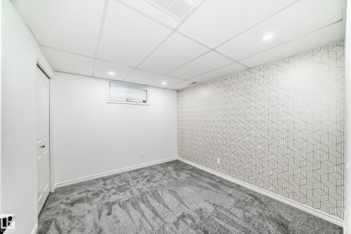 Finished below grade area featuring wallpapered walls, carpet flooring, a drop ceiling, an accent wall, and recessed lighting - 4008 37 Avenue, Edmonton, AB - Indoor