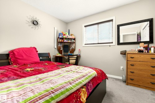 The room features soft gray wall paint and carpeted flooring - 8922 5 Avenue, Edmonton, AB - Indoor Photo Showing Bedroom