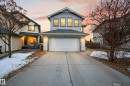 The property features light-colored siding, a front-facing garage with a white door, and a concrete driveway - 8922 5 Avenue, Edmonton, AB  - Outdoor With Facade 