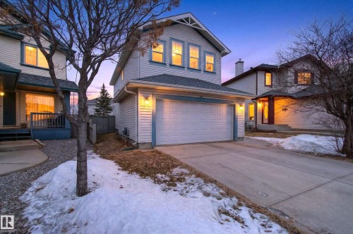 The property features a two-car garage, light-colored siding, and a paved driveway - 8922 5 Avenue, Edmonton, AB - Outdoor