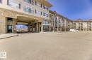 The property features a stone and siding exterior, with balconies visible on multiple levels - 125 1520 Hammond Gate Nw, Edmonton, AB  - Outdoor 