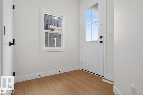 Entryway featuring light hardwood floors, a white door with clear glass panels, a window, and white walls - 5 Rosa Crescent, St. Albert, AB - Indoor Photo Showing Other Room