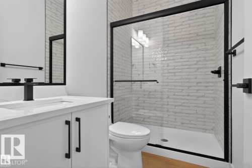 Bathroom featuring a white vanity with a rectangular sink, a black faucet, and a large mirror - 5 Rosa Crescent, St. Albert, AB - Indoor Photo Showing Bathroom
