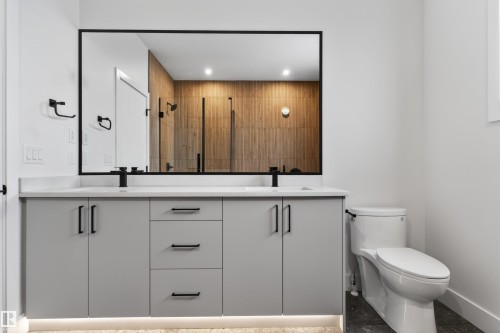 The bathroom features a double vanity with light gray cabinetry, white countertops, and matte black fixtures - 11 Redbud Way, St. Albert, AB - Indoor Photo Showing Bathroom