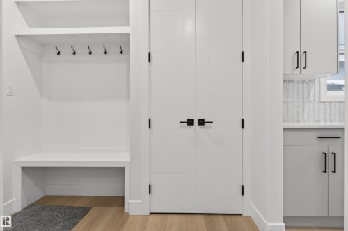 This entry area features a built-in bench and shelving with hooks, along with light wood flooring - 11 Redbud Way, St. Albert, AB - Indoor Photo Showing Other Room