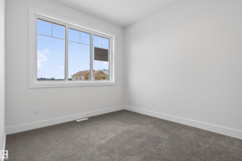 This room features a large window with white framing, providing natural light - 11 Redbud Way, St. Albert, AB - Indoor Photo Showing Other Room