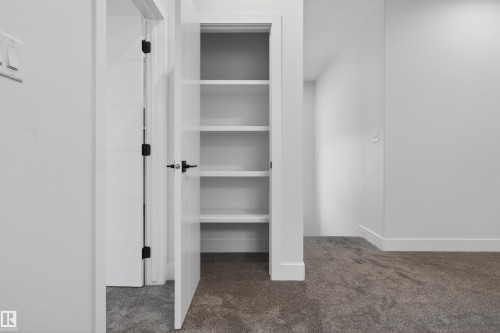 This property includes a closet with five shelving units, a white door with black hardware, and gray carpet - 11 Redbud Way, St. Albert, AB - Indoor
