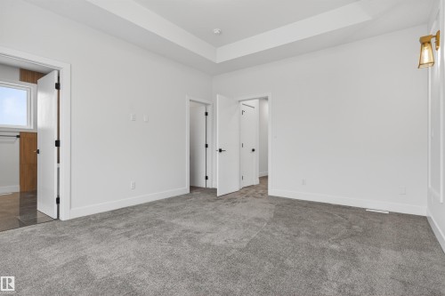 This room features a gray carpet, white walls, and a tray ceiling - 11 Redbud Way, St. Albert, AB - Indoor Photo Showing Other Room