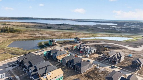 Developing residential area featuring a variety of housing styles and new construction, with proximity to natural water features - 11 Redbud Way, St. Albert, AB - Outdoor With Body Of Water With View