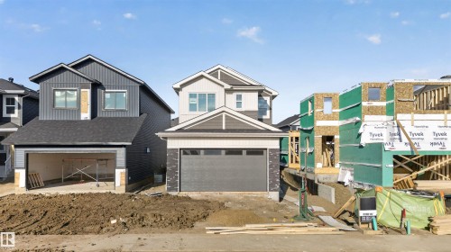 Exterior of a two-story residence featuring vertical and horizontal siding, a dark roof, and an attached garage with a dark gray overhead door - 11 Redbud Way, St. Albert, AB - Outdoor With Facade