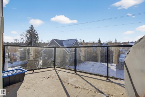 The property features an outdoor patio with a glass and metal railing, offering views of the surrounding area - 307 9750 94 Street, Edmonton, AB - Outdoor With Balcony