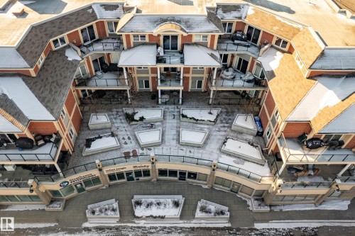 The property features a multi-level structure with red brick facade, balconies with black railings, and a snow-covered roof - 307 9750 94 Street, Edmonton, AB - Outdoor