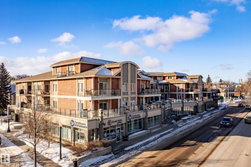 The property features a multi-story building with brick and stucco exterior finishes - 307 9750 94 Street, Edmonton, AB - Outdoor With Balcony