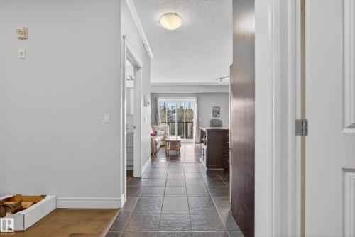 The property features tiled flooring in the entryway, leading into a living area with hardwood floors and a balcony - 307 9750 94 Street, Edmonton, AB - Indoor Photo Showing Other Room