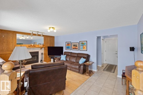Family Room On Main Floor With Wood-Burning Fireplace, Hardwood Flooring. - 12824 157 Avenue, Edmonton, AB - Indoor Photo Showing Other Room With Fireplace