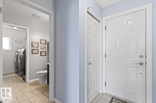 Hallway From Family Room Into 2 Piece Bathroom And Laundry Room. Door To The Garage. - 12824 157 Avenue, Edmonton, AB - Indoor Photo Showing Laundry Room