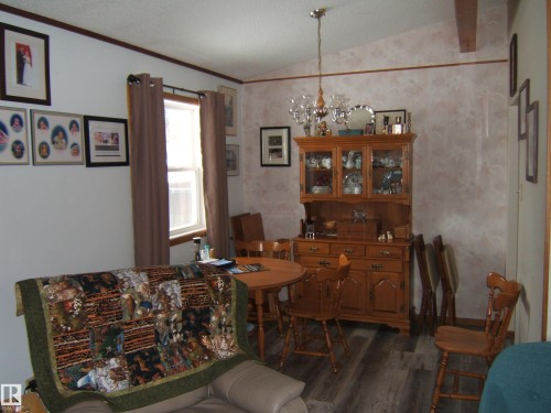 The interior features hardwood style flooring and a window providing natural light - 4702 52 Avenue, Two Hills, AB - Indoor