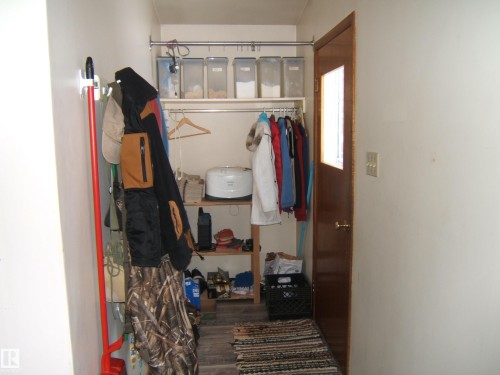 The entry area features a wood door with a window insert and a textured floor mat - 4702 52 Avenue, Two Hills, AB - Indoor