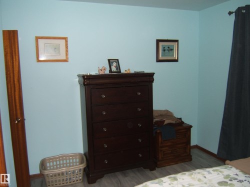 The room features light blue walls and wood-look flooring - 4702 52 Avenue, Two Hills, AB - Indoor Photo Showing Bedroom