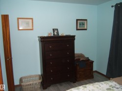The room features light blue walls and wood-look flooring - 