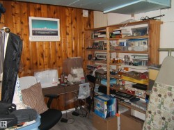 This room features wood paneling on one wall and a built-in wooden shelving unit - 