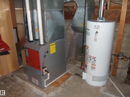 The property includes a water heater and a furnace with visible ductwork - 4702 52 Avenue, Two Hills, AB - Indoor Photo Showing Basement