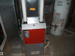 The property includes a gas furnace and a water heater, both visible on a concrete floor - 
