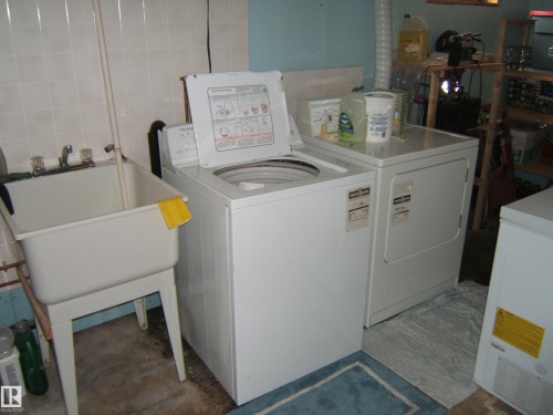 Dedicated utility area featuring a sink, washing machine, and dryer - 4702 52 Avenue, Two Hills, AB - Indoor Photo Showing Laundry Room