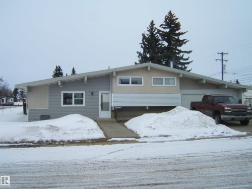 The property features a ranch-style exterior with light-colored siding and a contrasting gray section - 4702 52 Avenue, Two Hills, AB - Outdoor With Facade