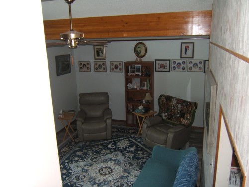 Living area with visible wood beam accents and a ceiling fan - 4702 52 Avenue, Two Hills, AB - Indoor
