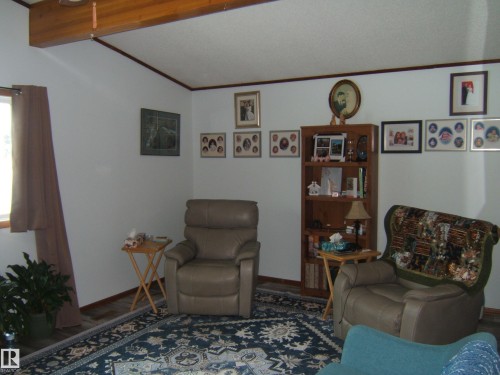The property features a room with light-colored walls and a beamed ceiling - 4702 52 Avenue, Two Hills, AB - Indoor