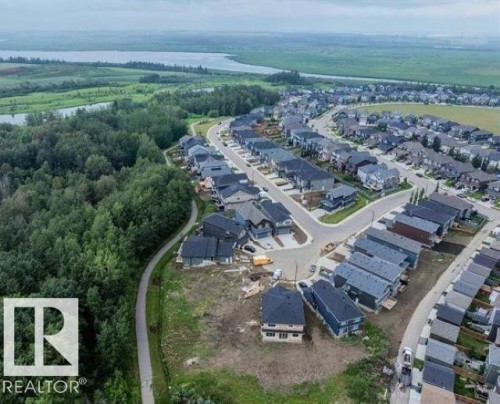 An aerial view showcasing the development with established homes, green spaces, and a nearby body of water - 1127 Gyrfalcon Crescent, Edmonton, AB - Outdoor With View