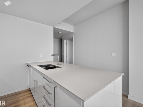 Kitchen island featuring a double sink, stainless steel faucet, and ample counter space - 2612 10360 102 Street, Edmonton, AB - Indoor Photo Showing Kitchen With Double Sink