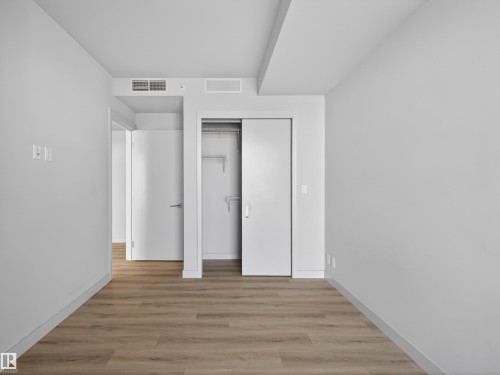 The room features light-coloured walls, wood-style flooring, and a closet with sliding doors. - 2612 10360 102 Street, Edmonton, AB - Indoor Photo Showing Other Room