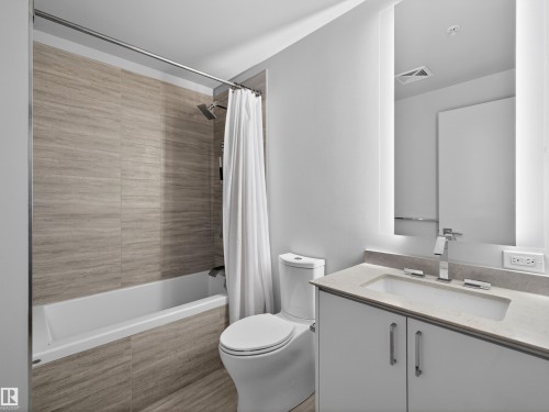 Bathroom featuring a vanity with a rectangular sink, a toilet, and a bathtub with a shower - 2612 10360 102 Street, Edmonton, AB - Indoor Photo Showing Bathroom